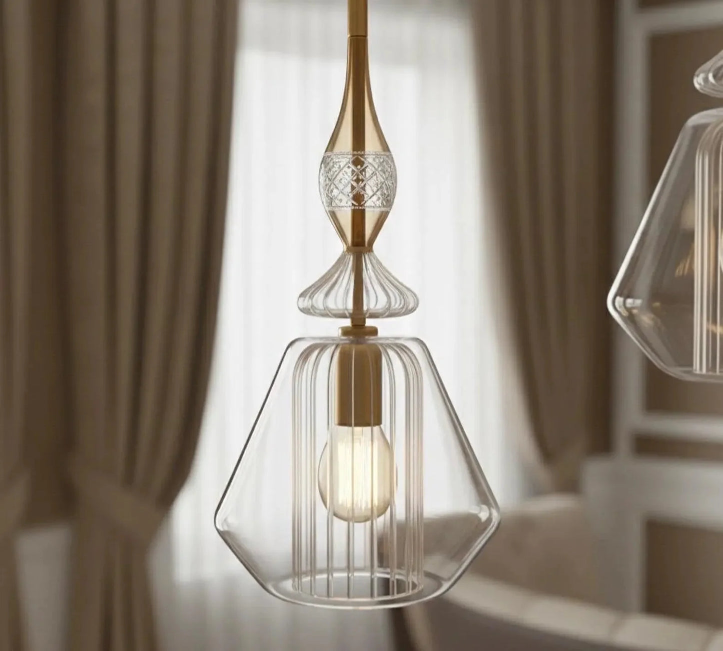 Modern pendant light with clear glass shade and gold accents in a room setting.