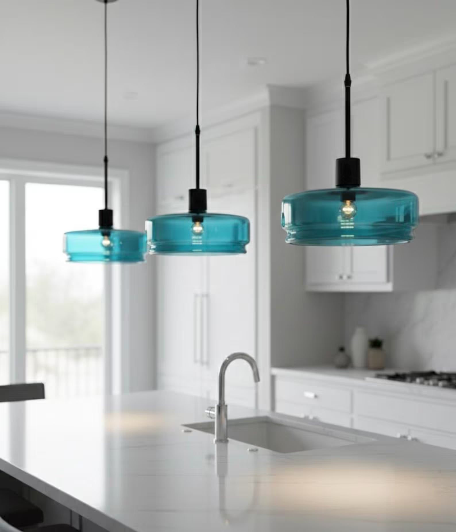 Three blue pendant lights hanging above a kitchen counter.